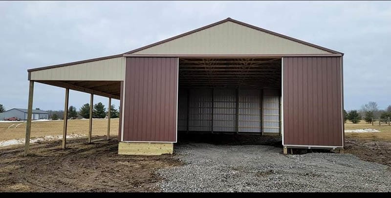 Agricultural pole barn with equipment opening and lean-to