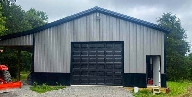 Post-frame equipment storage building with large overhead door