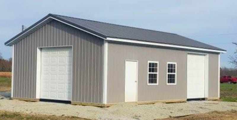 Gray post-frame workshop with overhead doors and windows